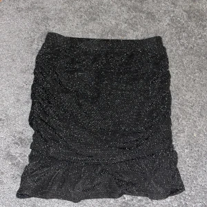 glittrig kjol - säljer min jättefina svarta glittra kjol från kappahl den är jätte töjbar men i storlek 164, själv har jag Xs men passar ändå, säljer för inte min smak riktigt 