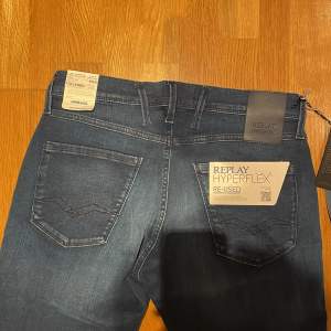 Säljer ett par helt nya och oanvända snygga mörkblå jeans från Replay Hyperflex-serien (anbass). De har en slim passform.  Kvitto finns!  Nypris: 1799, mitt pris 999kr.  Längden är 34 men går alltid att lägga upp till önskad längd!  Öppen för byten! 