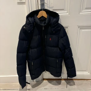 Ralph Lauren dunjacka  - Säljer min mörkblåa ralph lauren dunjacka. Jackan är i bra skick och är sparsamt använd. Det finns täcken på användning.