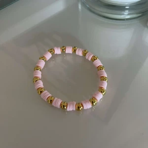 Rosa och guld armband - Säljer ett supergulligt armband med rosa och guld detaljer. Armbandet har små rosa pärlor varvat med glänsande guldfärgade kulor. Perfekt för att piffa upp vilken outfit som helst! 💖