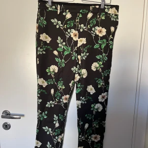 Blommiga byxor - Jättesnygga byxor med en liten slits nedtill och dragkedja + knapp i sidan. Varsamt använda.  Vill du ha fler bilder? Hör av dig så fixar jag det☘️