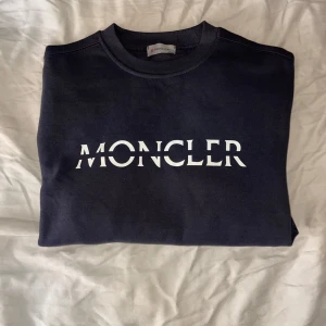 Moncler Mörkblå sweatshirt storlek M - Säljer en stilren mörkblå sweatshirt från Moncler helt oanvänd. Bra passform och  Storleken är M och den sitter bra på dig som pendlar mellan S och M.  