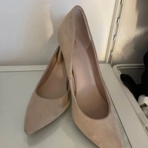 Beige pumps från H&M - Snygga beige pumps från H&M med spetsig tå och klack. Perfekta för en elegant look. Tillverkade i ett mjukt material som ger en lyxig känsla.