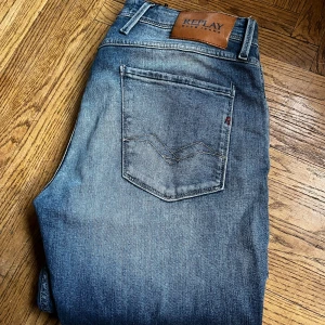 Blå jeans från Replay - Snygga blå jeans från Replay i modellen Anbass med slitningar. Jag är 195 och väger 85kg. I storlek 33.
