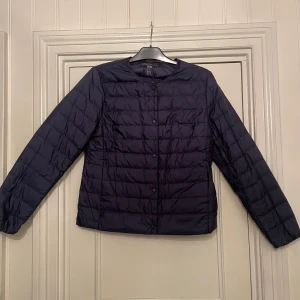 Mörkblå dunjacka från Uniqlo - Säljer en helt oanvänd mörkblå dunjacka från Uniqlo. 