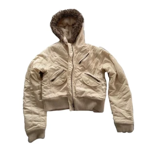 Beige jacka med fuskpäls🤍 - Snygg beige jacka med fuskpälsfodrad huva och dragkedja. Jackan har ribbade muddar och flera fickor med dragkedjor. Fin design och fin passform. Står ingen storlek lapp men enligt mig M/L. Skriv vid frågor! 