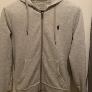 Grå hoodie från Polo Ralph Lauren  - Säljer en stilren grå hoodie från Polo Ralph. Nyskick 9.5/10 andvänd endast fåtal gånger.