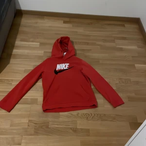 Röd hoodie från Nike och pris kan diskuteras  - Säljer en snygg röd hoodie från Nike med deras klassiska logga i vitt på bröstet. Perfekt för en avslappnad stil. Hoodien har långa ärmar och en bekväm huva.