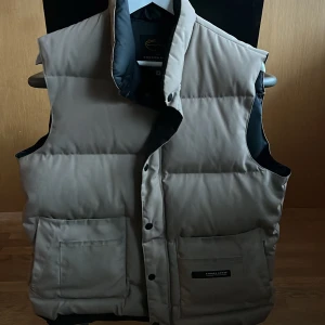 Beige dunväst från Canada Goose - Säljer en snygg beige dunväst från Canada Goose. 