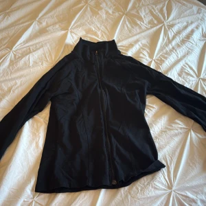 Svart jacka med dragkedja - Säljer en svart jacka från Gina med dragkedja. Jackan har långa ärmar. Enkel och stilren design som passar till det mesta.