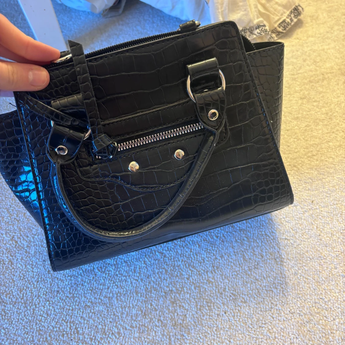 Svart handväska med krokodilmönster