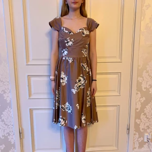 Blommig klänning - Jättefin klänning i skönt material med ett fint blommigt mönster. Storlek L Modellen på bilden är 173 cm och har storlek 38 i de flesta andra kläder. Aldrig använd. Vi har lagt ner vår klänningsbutik och säljer ut. Ny pris är 2000-3000kr