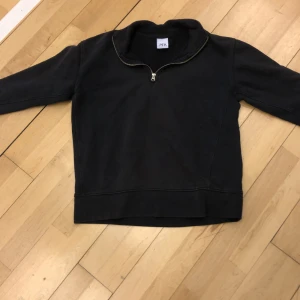 Svart tröja med dragkedja från Zara - Säljer en svart tröja från Zara med dragkedja vid halsen. Tröjan har långa ärmar och en enkel design som passar perfekt för en avslappnad stil. Perfekt för kyligare dagar.