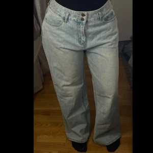 Ljusblå jeansbyxor - Snygga ljusblå jeansbyxor med hög midja och en avslappnad passform. Byxorna har en klassisk femficksdesign och stängs med två knappar och dragkedja. Perfekta för en casual look.
