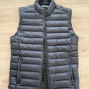 Oanvänd mörkblå dunväst från J.Lindeberg. Stl XS - J.Lindeberg. Ny oanvänd ”MICK LIGHT WEIGHT VEST - VÄST - NAVY”. Endast testad. Sonen fick den i julklapp, men inser nu att den är för liten. Slutsåld! Nypris 2195kr 
