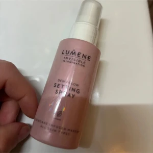 Setting Spray från Lumene - Lumene Invisible Illumination Dewy Glow Setting Spray i en rosa flaska. Perfekt för att fixera smink och ge en fräsch lyster. 