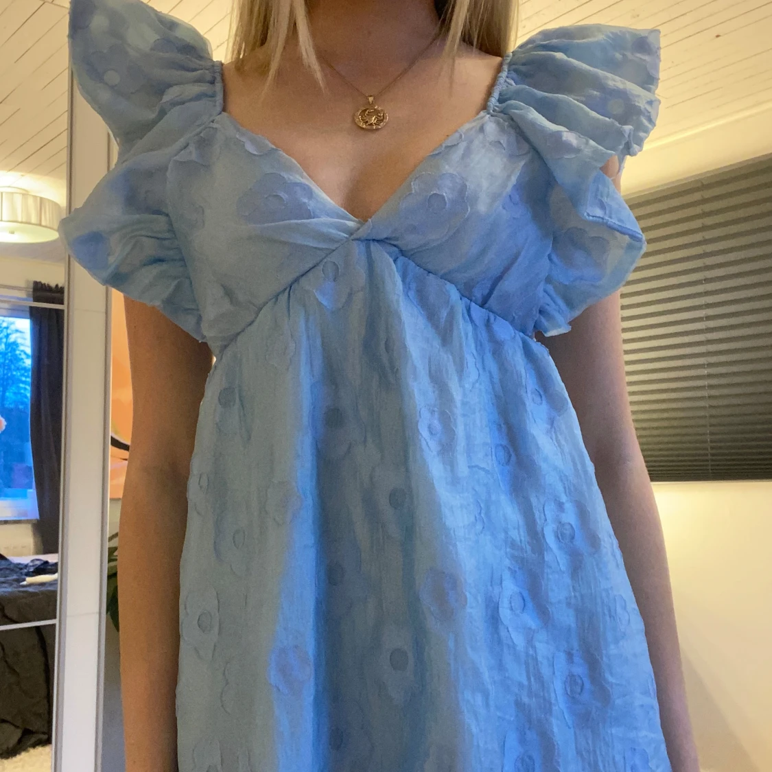 Ljusblå klänning med volangdetaljer