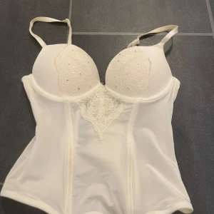 Korsett  - Vit korsett med rhinestones och spets med push up och knäppen i ryggen. Helt fantastisk! Finns ingen lapp men skulle uppskatta att den är XS/S.