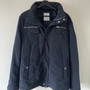 Marinblå field jacka från J.Lindeberg - Snygg marinblå field jacka från J.Lindeberg med dragkedja och knappar! (Storlek M/L) (Orginalpris 4000kr) Skriv vid minsta fundering!