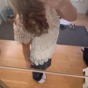 Vit spetsblus - Vit spetsblus ifån Falsh Woman. Fina spets detaljer på både bak och framsida, samt knappar vid nacken. Liten krage som ni kan se på bild 2. Bra skick och skönt material!