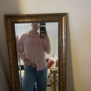 Röd och vit randig skjorta - Jättesnygg rödvitrandig skjorta i avslappnad och ledig stil. Snygg till både jeans och kjol, perfekt att ha i garderoben till vår och sommar