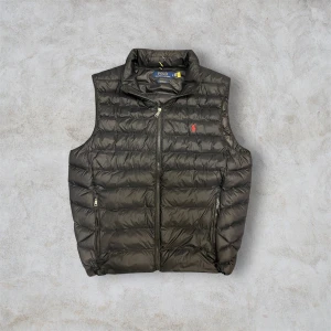 Svart dunväst från Ralph Lauren - Fett Ralph lauren väst använd en gång inga defekter eller täcken på den e använd, ny pris 3400kr! Om man har frågor eller vill ha mer bilder bara o skriva!