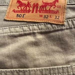 Beige Levis 501 jeans - Snygga beige Levis 501 jeans med klassisk design. De har en rak passform och är tillverkade i slitstarkt material. Perfekta för en avslappnad stil.