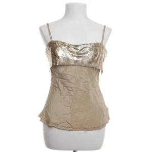 Festtop - Råsnyggt guldigt linne helt i siden med paljetter upptill i metall och dubbla smala axelband. Perfekt som en festtop!! ✨Den har en dekorativ kant längst ner som ger en extra touch. Storlek M men tycker den sitter mer som en S ✨Köpt för 900, har aldrig använt den själv 🌹Skriv om du har några funderingar 💞