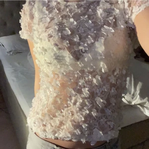 Vit spetsblus Ida Sjöstedt - Säljer den här blommiga blusen från Ida Sjöstedt som är använd sparsamt så den har inga defekter. Så fin till en kjol eller ett par jeans på sommaren 🤍Nypris var ca 1000kr och den passar storlek XS/S/M. Skriv för frågor 🪩❤️‍🔥