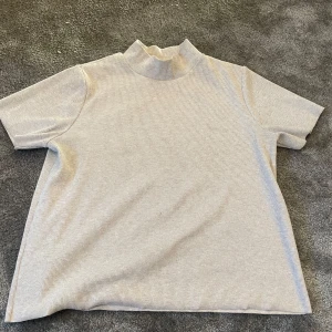Beige ribbad polotopp från Pull&Bear - Säljer en mysig beige ribbad polotopp från Pull&Bear. Toppen har korta ärmar och en hög krage. 80kr+frakt.😀 Den är i storlek L men sitter jättefint på mig som är en s också🥰