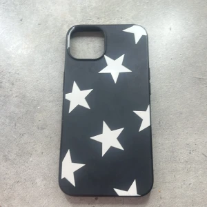 Svart mobilskal med vita stjärnor, iPhone 13 - Ett svart mobil skal till iPhone 13, mycket bra  skick 