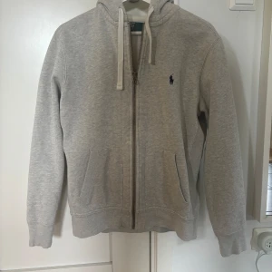 Ralph lauren zip hoodie grå - Säljer min gråa Ralph Lauren tröja eftersom den är för liten. Sparsamt använd och den har inga fläckar eller slitage. Storlek M men jag har medium egentligen och den är lite liten för mig. Nypris: 2095kr 