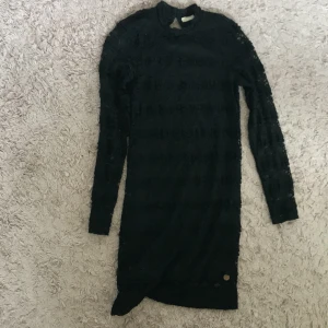 Svart spetsklänning - Säljer en elegant svart spetsklänning från märket Ü. Klänningen har en tight passform och är långärmad, perfekt för festliga tillfällen. Den är tillverkad i ett vackert spetsmaterial som ger en lyxig känsla. Passar bra till både höst och vinter.