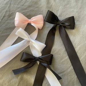 Hårrosetter i tre färger - Säljer tre eleganta hårrosetter i svart, vitt och rosa. Varje rosett har långa band och en praktisk klämma på baksidan för enkel fastsättning i håret. Perfekt för att ge en söt och stilren touch till din frisyr.🖤💖3 för 30 oavsett design och färg