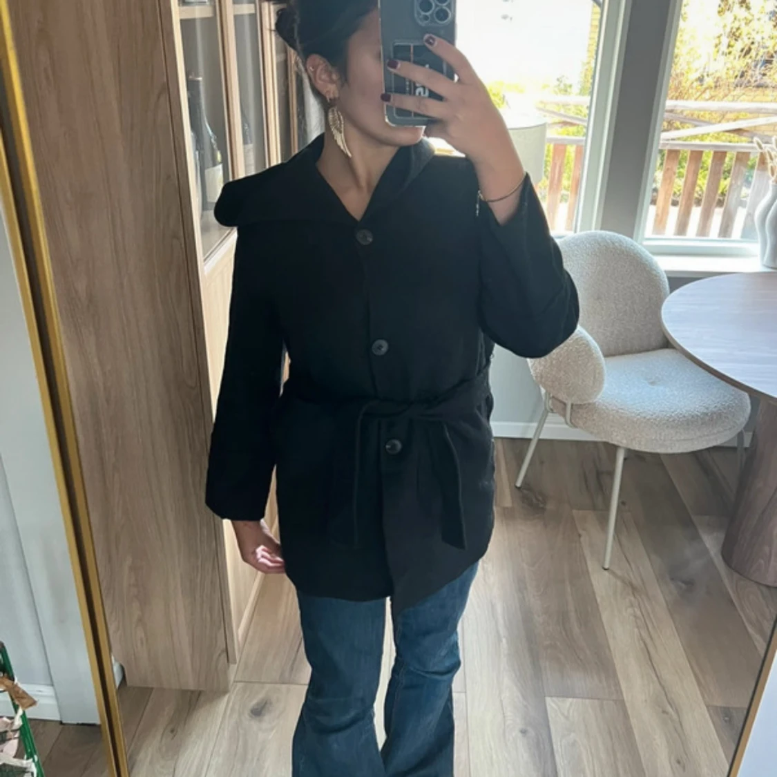 Svart kappa med knappar och bälte