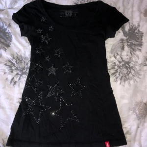 Svart kortärmad topp med stjärndetaljer från edc - Svart kortärmad topp från edc med snygga sjärndetaljer på framsidan🥰 