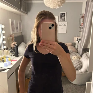 Mörkblå t-shirt - Säljer en klassisk mörkblå t-shirt med v-ringning. Perfekt basplagg för alla tillfällen. T-shirten har korta ärmar och en figurnära passform.