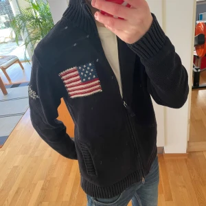 Stickad Gant USA Full Zip Cardigan - Säljer en sjukt fet USA full zip cardigan från gant som inte säljs längre. Den är i ett tjockt materiel så passar perfekt nu till våren. Tröjan är i bra skick, inga fläckar och sitter i storlek M. Hör gärna av er vid frågor eller funderingar!! Priset går såklart att diskutera!!