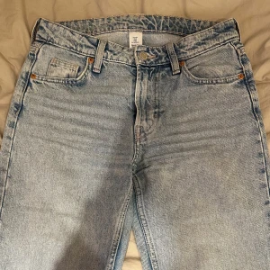 Jeans - Snygga ljusblå jeans från h&m med en straight passform och midwaist. De har en klassisk femficksdesign och en knappgylf. Perfekta för en avslappnad stil.