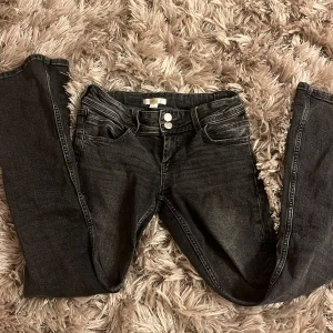 Grå/svarta jeans med knappar - Snygga grå/ svarta jeans med knappar framtill. Jeansen har två pyttesmå vita fläckar, men de går bort med speciellt tvättmedel! Har använt 2 gånger men de är lite för små för mig😔Köpte för 300kr men säljer för 150kr