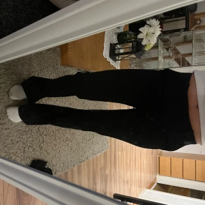 Svarta kostymbyxor  - Snygga svarta kostymbyxor med medelhög midja och rak passform. Perfekta för en stilren look. De är tillverkade i ett bekvämt material som ger en skön känsla hela dagen.