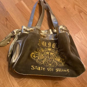 Vintage juicy couture väska - Säljer vintage juicy couture väska då den ej kommer till användning längre. Lite slitage i handtagen annars bra skick! 27 cm i höjd, 32 cm i bredd & 17 cm i ”djupet”.