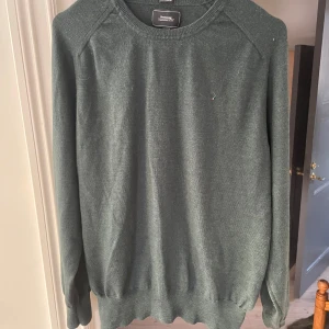 Grön merinoulltröja från Boomerang - Säljer en stilren mörk grön tröja från Boomerang i 100% merinoull. Tröjan har en klassisk design med långa ärmar och rund halsringning. Perfekt för kyligare dagar den är i storlek L men sitter betydligt mindre som typ en m eller s. Hör av er vid minsta intresse😊