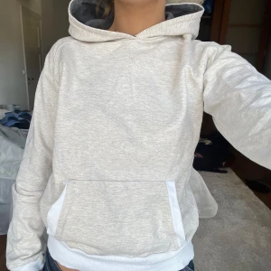 Beige hoodie med ficka - Säljer en stilren beige hoodie med en praktisk magficka och vit mudd. Perfekt för en avslappnad look. Huvan har en mörkare insida som ger en snygg kontrast.