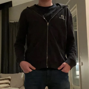 Woolrich - Säljer en svart hoodie med dragkedja från Insolight. Den har en enkel design med en liten logotyp på bröstet och är långärmad. Perfekt för en avslappnad stil. Vid frågor eller funderingar är det bara att höra av er!