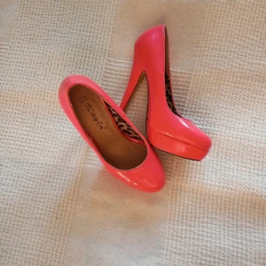 Corallrosa lack pumps med leopardmönstrad insida - Snygga rosa pumps med hög klack och leopardmönstrad insida. Perfekta för att ge en färgklick till din outfit. Klacken mäter cirka 13cm och ger en elegant höjd.