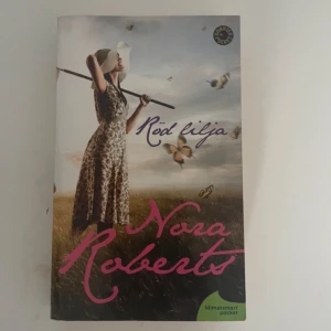 Röd lilja - Säljer boken 'Röd lilja' av Nora Roberts. Det är en klimatsmart pocketutgåva som ingår i en trilogi om tre kvinnor och deras livsöden. Perfekt för dig som gillar romantik och dramatik. Boken är utgiven av Bonnier Pocket.