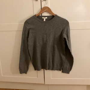 Tunn stickad tröja - Säljer en stilren grå tröja från H&M. Tröjan har långa ärmar och en rund halsringning, perfekt för kyligare dagar. Den är enkel att matcha med olika outfits och passar bra till både vardag och mer uppklädda tillfällen. 💛 Är storlek M men passar mig som brukar ha XS-S ❤️