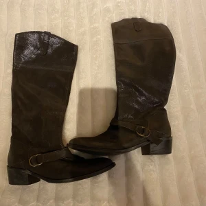 Bruna stövlar med spänne - Snygga bruna stövlar i skinn med dekorativa spännen. Dem är bruna med detaljer som skimrar lite, perfekt till vardag med också till festen! Väldigt bekväma att ha på sig också💋
