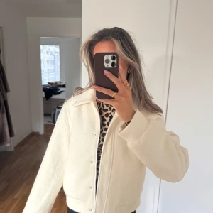 Bomberjacka i bouclé - Supersnygg jacka med både dragkedja och knappar från Lojsans kollektion med NAKD. Dragkedjan blir gömd när den är stängd. Känns tung och rejäl i materialet. Den är rymlig och lite oversized. Aldrig använd.